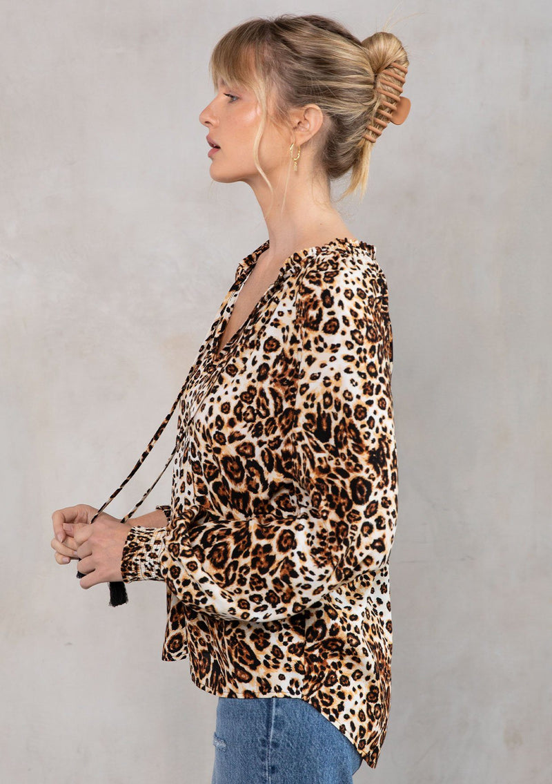 [Color: Camel/Brown] Model wearing a chic leopard print peasant blouse with a split neckline and tassel ties. 