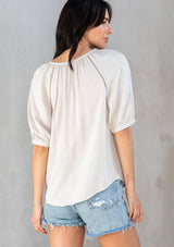[Color: Vanilla Bean] A model wearing an off white puff sleeve button front blouse. 