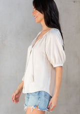 [Color: Vanilla Bean] A model wearing an off white puff sleeve button front blouse. 