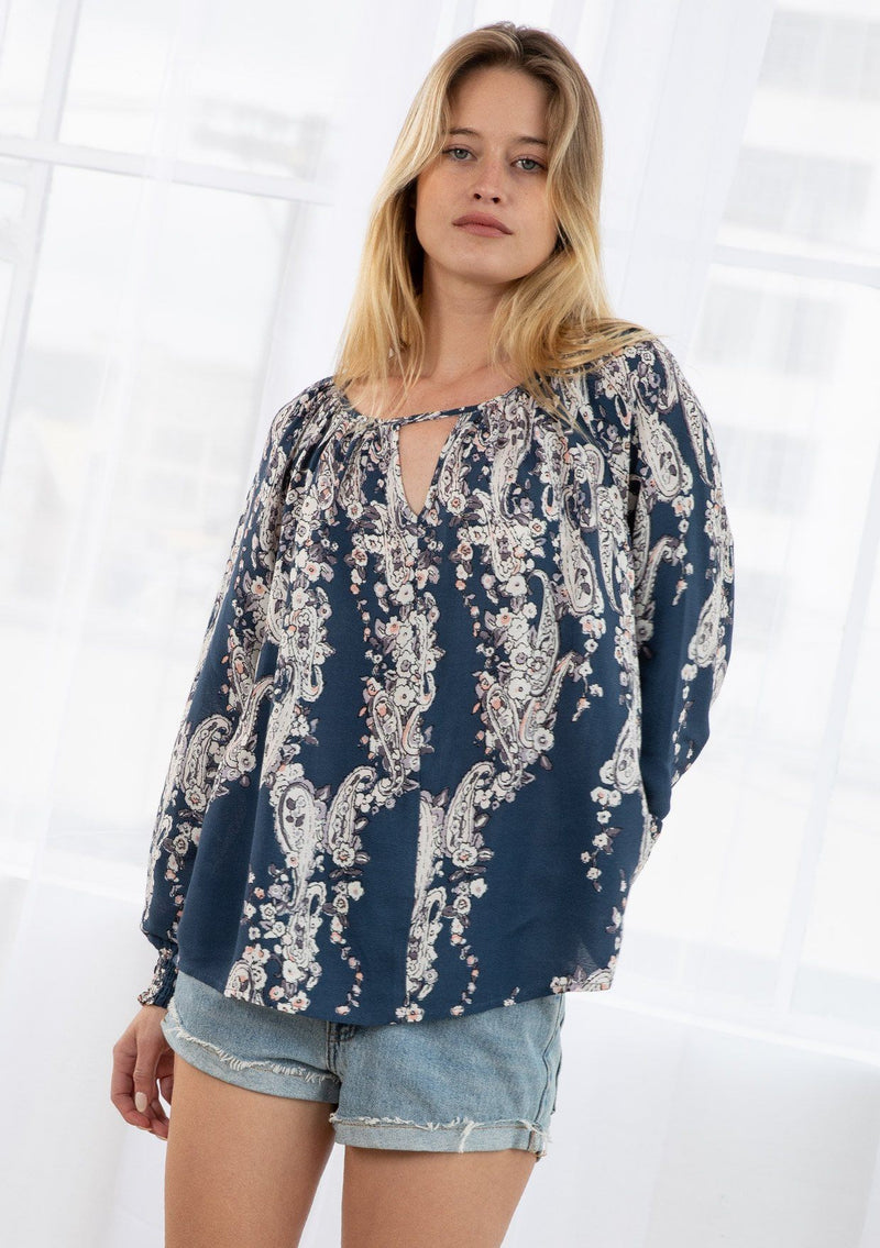 [Color: Denim/Ivory] A blond model wearing a vintage floral print peasant top. With a front keyhole detail and long voluminous sleeves with a smocked elastic wrist cuff.