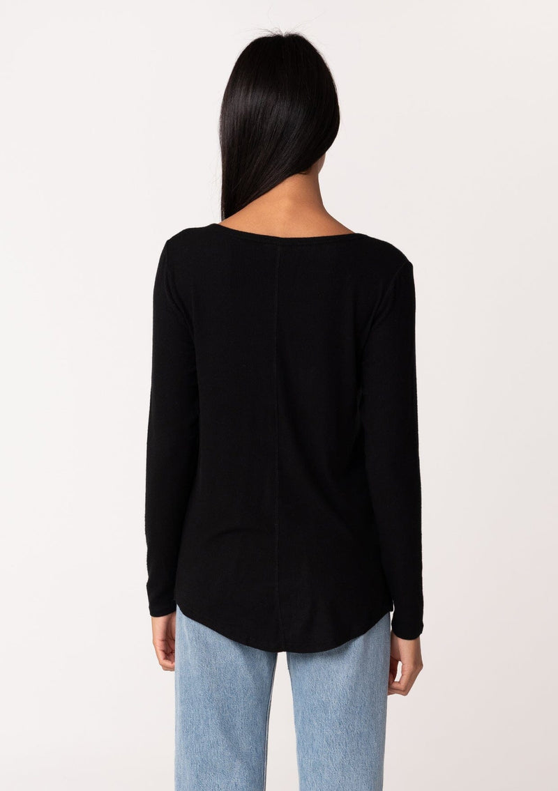 [Color: Black] A back facing image of a model wearing a black micro rib long sleeve tee with a v neckline and neck ties. 