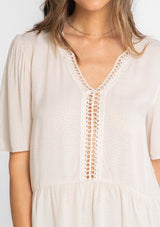[Color: Vanilla Bean] A model wearing a flowy cream colored short sleeve top. 