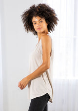 [Color: Mushroom] A model wearing a soft mushroom grey tank top with a cutout shoulder detail. Featuring a v neckline and a shirt tail hemline. 