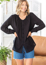 [Color: Black] A woman wearing a sheer cotton voile button front top. Featuring pretty floral embroidered details throughout, voluminous long sleeves with a button cuff closure, and a large button up front.