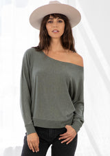 [Color: Army Green] A model wearing an army green French terry top. With long dolman sleeves and a boat neckline that can be worn on or off the shoulder. 