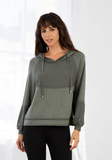 [Color: Army Green] A model wearing an army green soft knit pullover sweatshirt. With a drawstring hoodie, long raglan sleeves, raw unfinished hemlines, exposed seams, and contrast inside out details. 