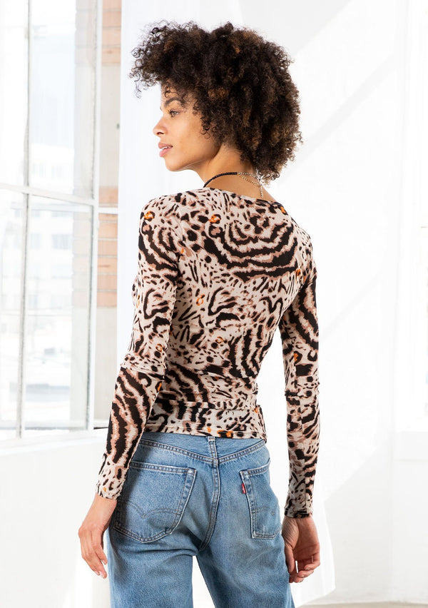 [Color: Cream/Taupe] A model wearing a sheer mesh slim fit top in an animal print. With long sleeves and a round neckline. 