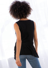 [Color: Black] A model wearing a black tank top in textured jacquard. With a v neckline, a drawstring waist, tassel tie side detail, and thicker tank top straps. 