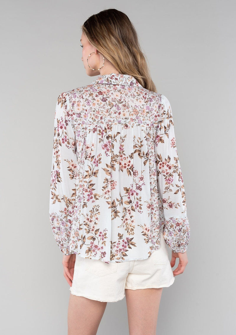[Color: Mint/Rose] A back facing image of a blonde model wearing a vintage inspired bohemian blouse in a pink mixed floral print. With long sleeves, a collared neckline with ties, a self covered button front, and a flowy relaxed fit. 