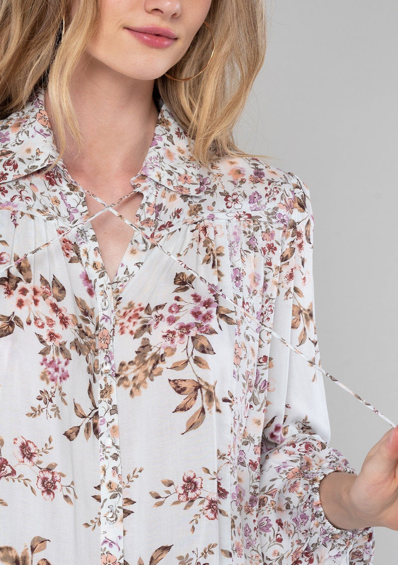 [Color: Mint/Rose] A close up front facing image of a blonde model wearing a vintage inspired bohemian blouse in a pink mixed floral print. With long sleeves, a collared neckline with ties, a self covered button front, and a flowy relaxed fit. 