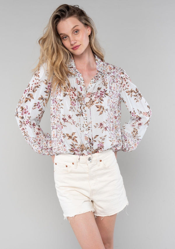 [Color: Mint/Rose] A front facing image of a blonde model wearing a vintage inspired bohemian blouse in a pink mixed floral print. With long sleeves, a collared neckline with ties, a self covered button front, and a flowy relaxed fit. 