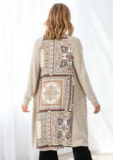 [Color: Ivory/Taupe] A model wearing a soft knit mid length cardigan with a contrast woven back in a patchwork print. With long sleeves, an open front, and two side patch pockets. 