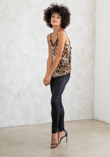 [Color: Camel/Brown] A model wearing a brown leopard print camisole tank top. With a lace trimmed v neckline, spaghetti straps, and an adjustable tie back detail. 