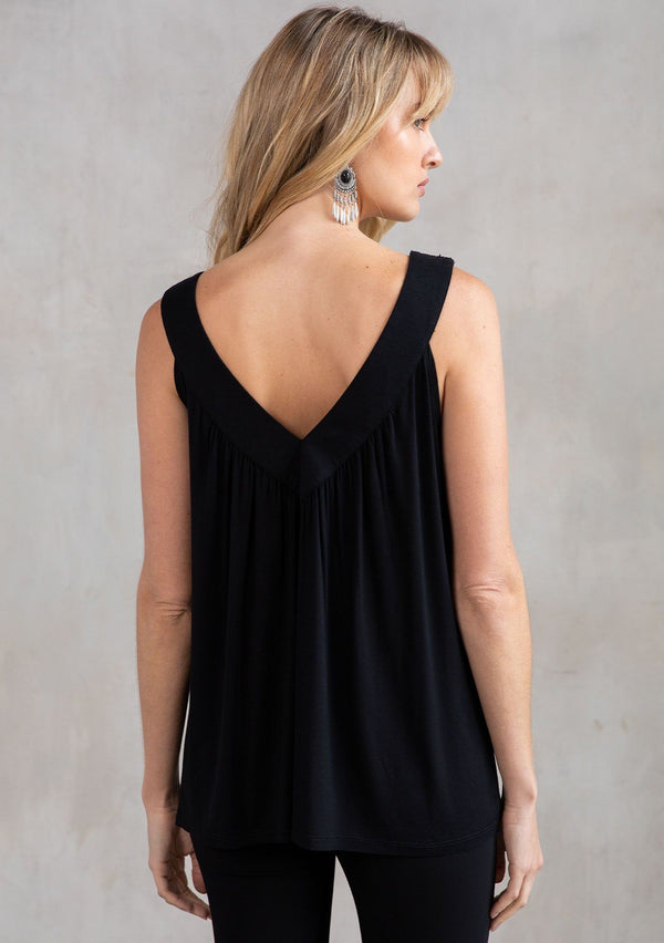[Color: Black] A model wearing a black soft knit, holiday ready tank top with a beaded accent, a v neckline in front and back, and a flattering swing silhouette. 