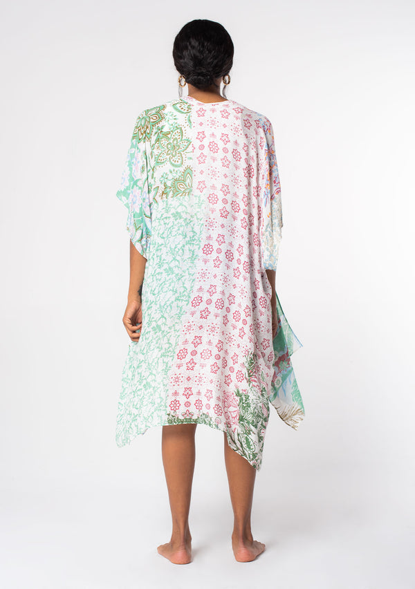 [Color: Mint/Sky] A model wearing a sheer lightweight mid length kimono in a mint green and sky blue mixed floral print. With half length kimono sleeves, side slits, and an open front.