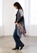 [Color: Midnight/Peach] A model wearing a soft and lightweight navy blue mid length kimono in a mixed bohemian print. With half length kimono sleeves, side slits, and an open front. 