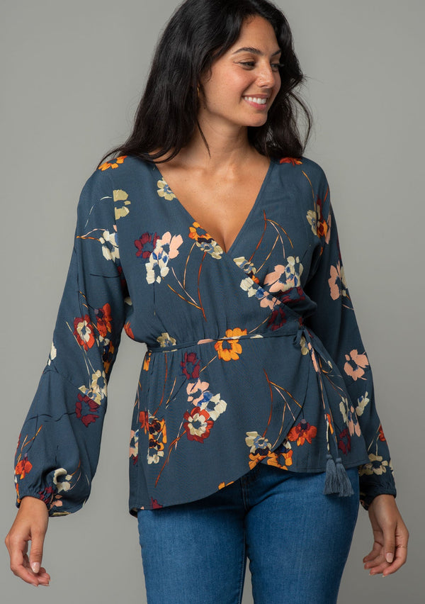 [Color: Grey/Wine] A front facing image of a brunette model wearing a slate blue grey long sleeve wrap top with a wine red floral print. 