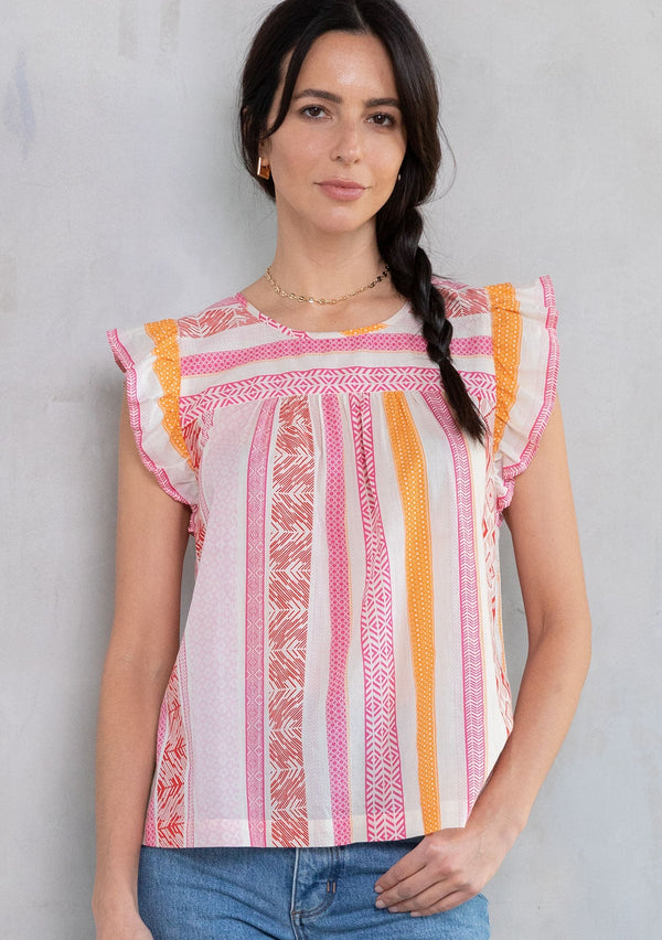 [Color: Fuchsia/Orange] A model wearing a pink and white multi pattern stripe cotton bohemian top with a short ruffled cap sleeve. 