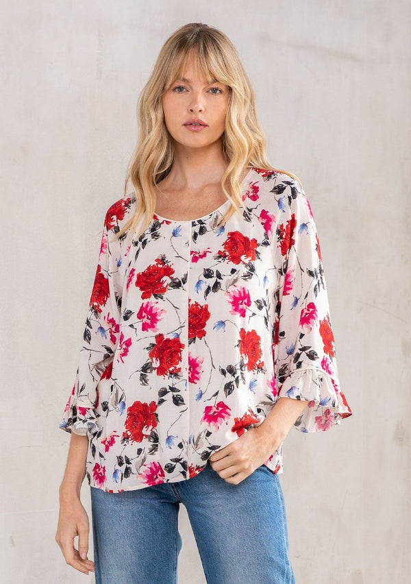[Color: Cream/Red] A model wearing a romantic red rose floral print blouse, with bohemian three quarter length flutter sleeves and a round neckline. 