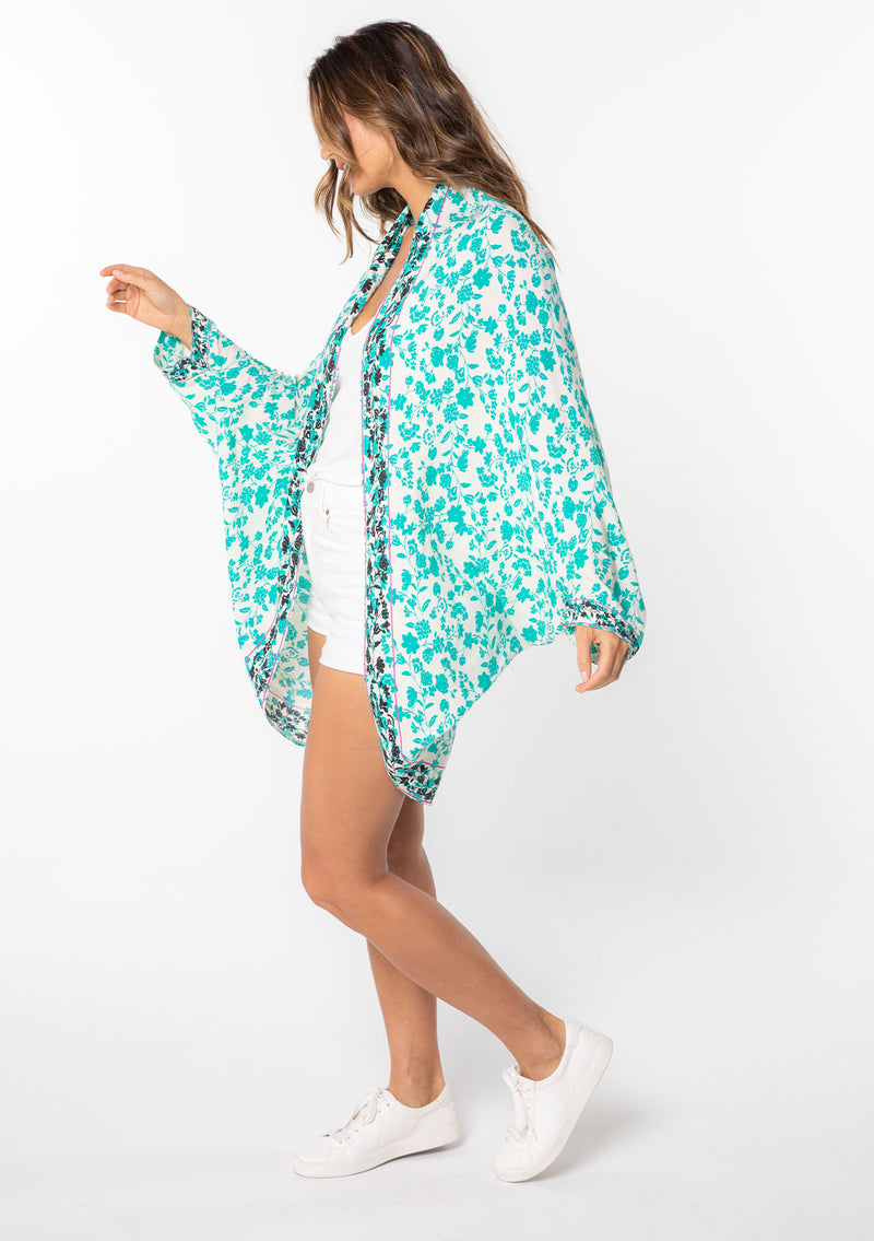 [Color: Off White/Jade] A model wearing a white and teal floral print kimono with long sleeves and a rounded cocoon fit. 