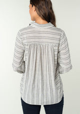 [Color: White/Black] A back facing image of a brunette model wearing a classic bohemian shirt in a white and black stripe. With a button front, long sleeves, and a classic collared neckline. 