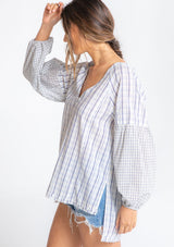 [Color: Natural/Blue] A model wearing a cotton blue and off white plaid oversized shirt with oversized long sleeves and a v neckline. 