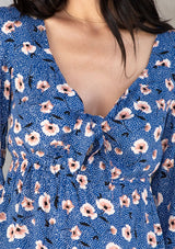 [Color: Navy/Cream] A model wearing a vintage inspired blouse in a navy blue floral print. With a sweetheart neckline, a tie front detail, and long sleeves.