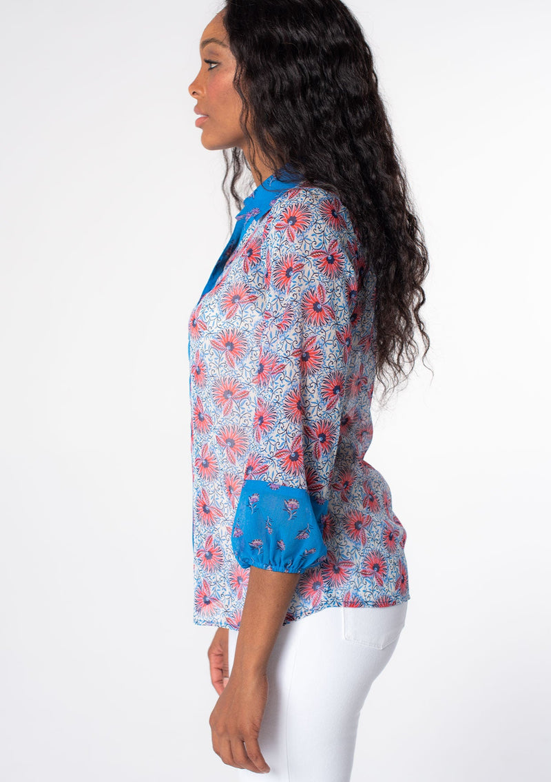 [Color: Ivory/Blue] A model wearing a blue, white and red mixed floral print sheer chiffon button front blouse. A vintage inspired shirt with contrast sleeve detail and classic collared neckline. 