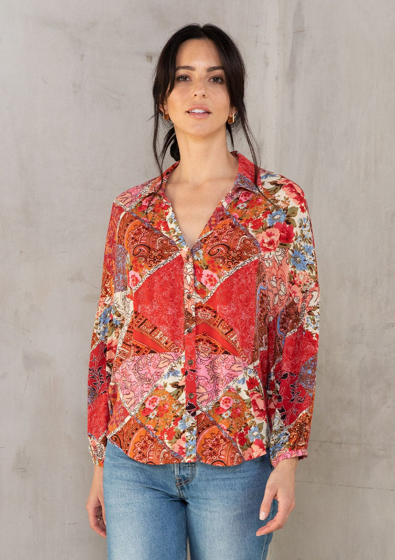 [Color: Ivory/Red] A model wearing a red bohemian button up shirt in a floral patchwork print. With a split collared v neckline and voluminous long sleeves. 