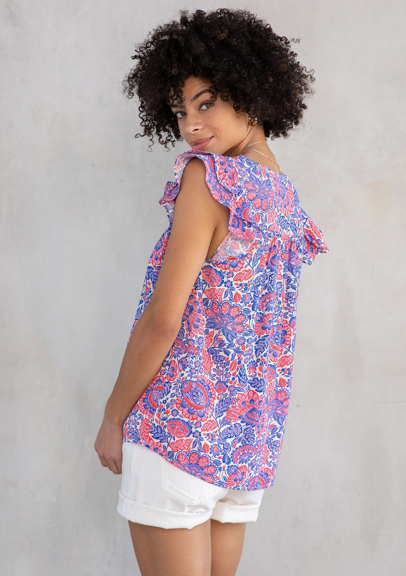 [Color: Ivory/Cobalt] A model wearing a classic bohemian short flutter cap sleeve top in a red and blue paisley print. With a split v neckline and tassel ties. 