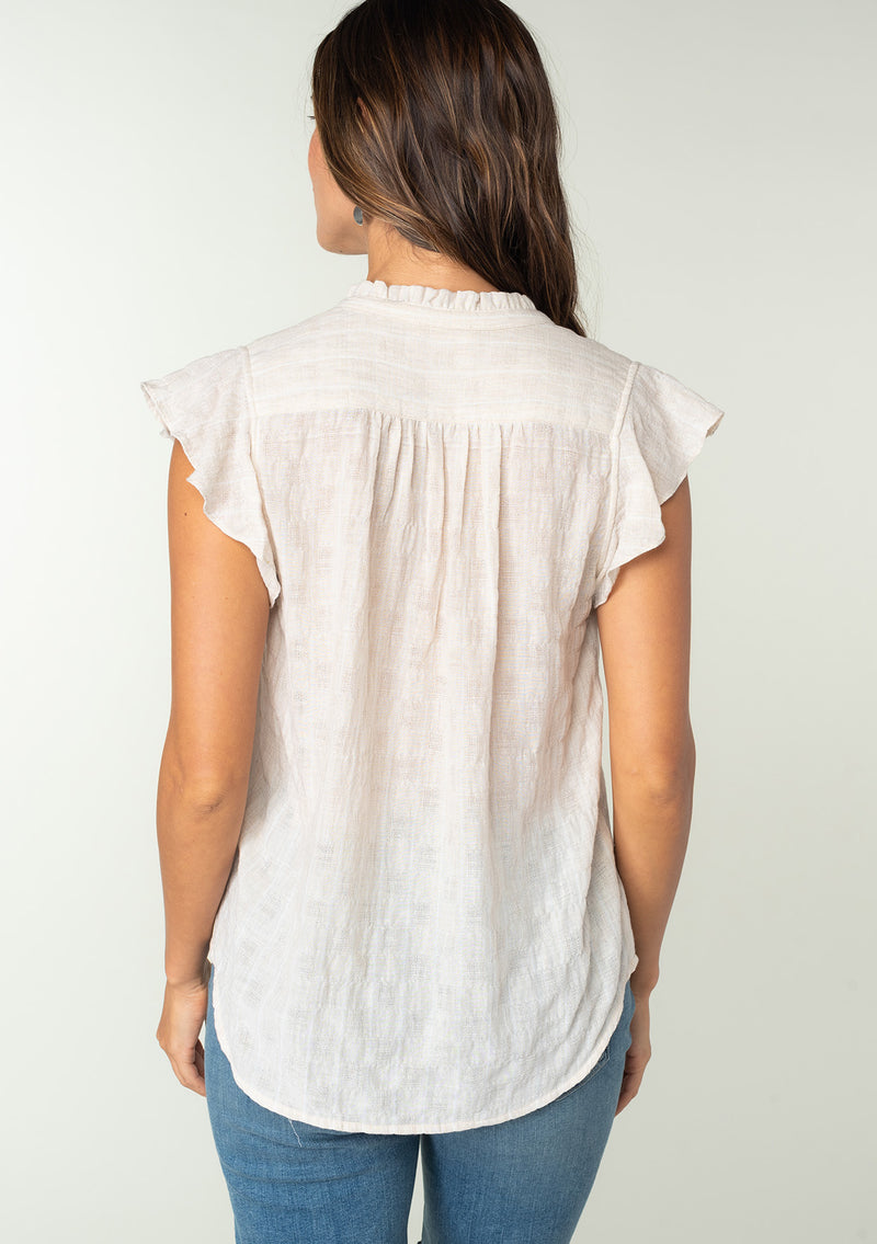 [Color: Oatmeal] A back facing image of a brunette model wearing a sheer cotton button front top in a striped jacquard. With short flutter sleeves and a ruffled neckline. A best selling bohemian top. 