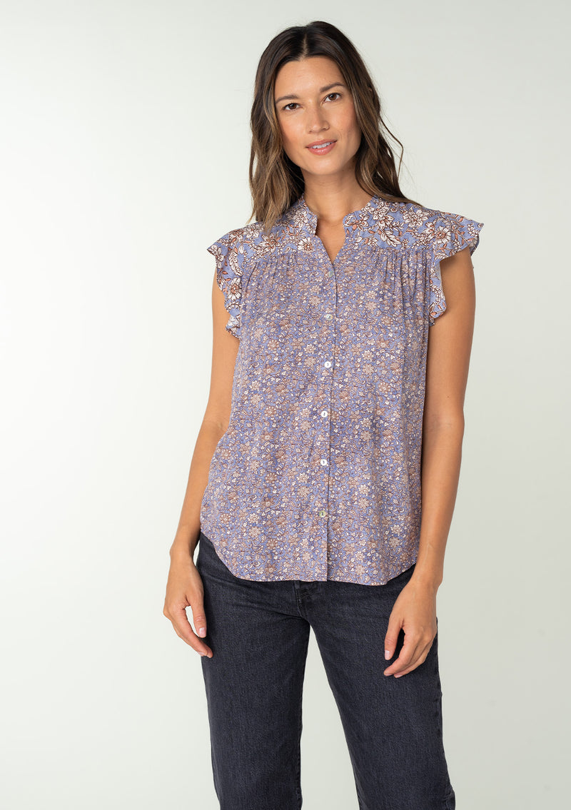 [Color: Grey/Natural] A front facing image of a brunette model wearing a best selling Lovestitch button front top in a grey and natural floral print. With short flutter sleeves and a ruffled neckline. 