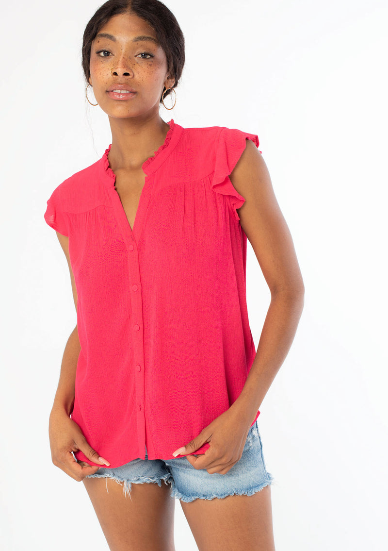 [Color: Hot Pink] A front facing image of a black model wearing a bright pink crinkle gauze short sleeve flutter top with a button front and a ruffled neckline.