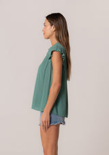 [Color: Seaglass Green] A side facing image of a brunette model wearing a sea green crinkle gauze short sleeve flutter top with a button front and a ruffled neckline.