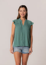 [Color: Seaglass Green] A front facing image of a brunette model wearing a sea green crinkle gauze short sleeve flutter top with a button front and a ruffled neckline.