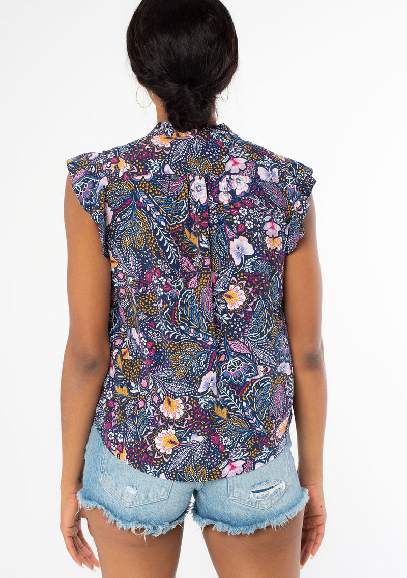 [Color: Navy/Berry] A back facing image of a black model wearing a navy blue and berry purple vintage floral print top with short flutter sleeves and a button front. 