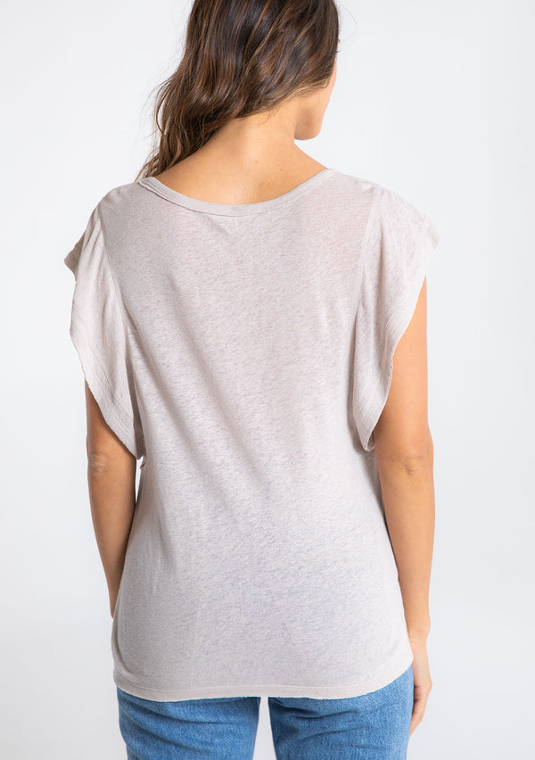 [Color: Mushroom] A model wearing a beige linen blend tee shirt with a short ruffled sleeve. 