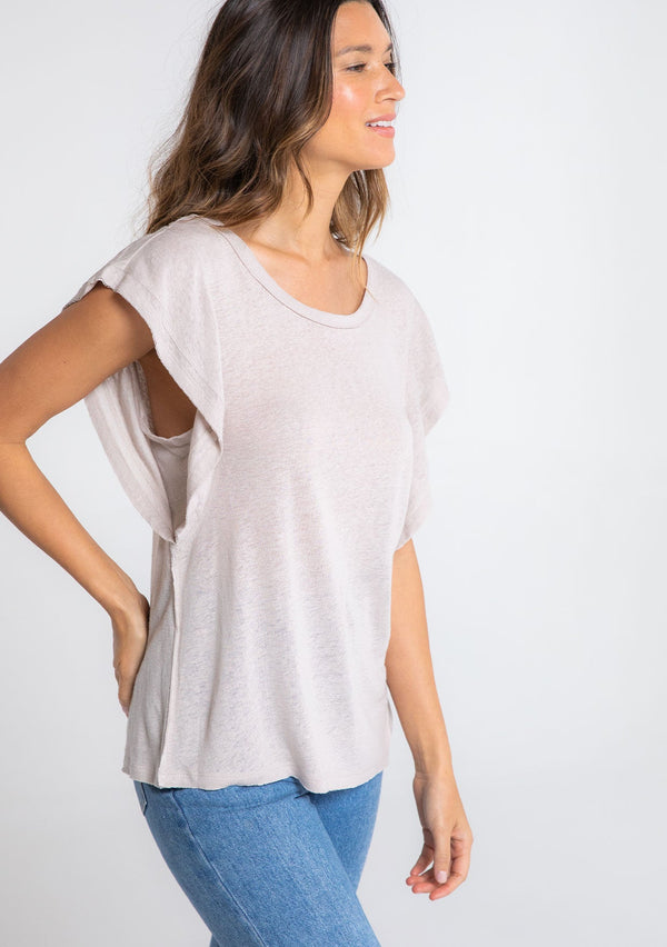 [Color: Mushroom] A model wearing a beige linen blend tee shirt with a short ruffled sleeve. 