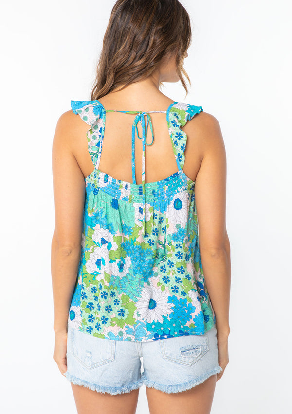 [Color: Green/Aqua] A model wearing a flowy bohemian top in a bright retro blue and green floral print, with short flutter sleeves. 