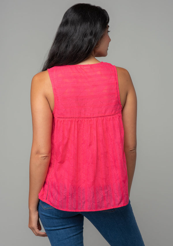[Color: Watermelon] A back facing image of a brunette model with long wavy dark hair wearing a bright pink bohemian sleeveless tank top with a split v neckline and tassel ties.