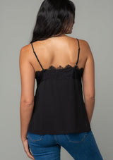 [Color: Black] A back facing image of a brunette model wearing a black lace trim camisole with a v neckline, adjustable spaghetti straps, and a flowy relaxed fit. 