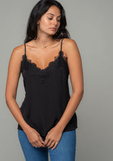 [Color: Black] A front facing image of a brunette model wearing a black lace trim camisole with a v neckline, adjustable spaghetti straps, and a flowy relaxed fit. 