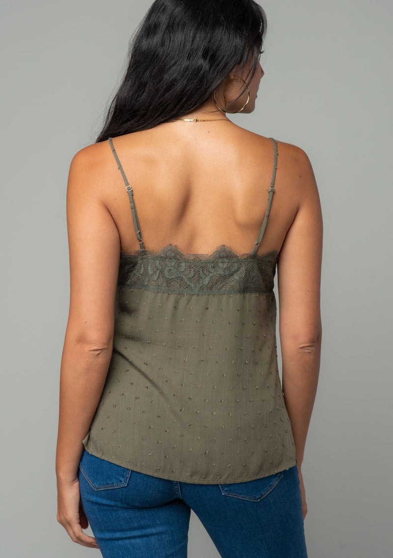 [Color: Olive] A back facing image of a brunette model wearing an olive green clip dot camisole with a lace trim v neckline and adjustable spaghetti straps. 