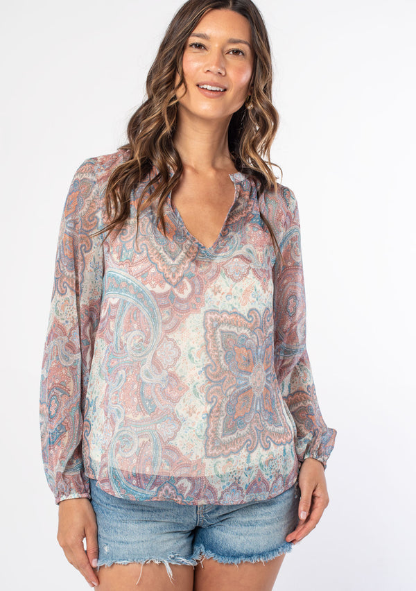 [Color: Blush/Aqua] A woman wearing a bohemian sheer pink paisley peasant top with long sleeves and a v neckline. 