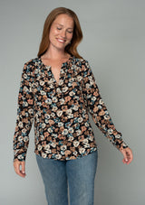 [Color: Black/Natural] A half body front facing image of a red headed model wearing a lightweight long sleeve top in a black and natural floral print. With a split v neckline and a relaxed flowy fit. 