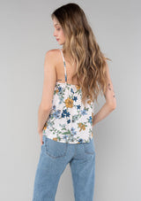 [Color: Natural/Mustard] A back facing image of a blonde model wearing a sexy bohemian tank top in a blue and yellow floral print. A spring camisole with a self covered button front, a v neckline, and adjustable spaghetti straps. 