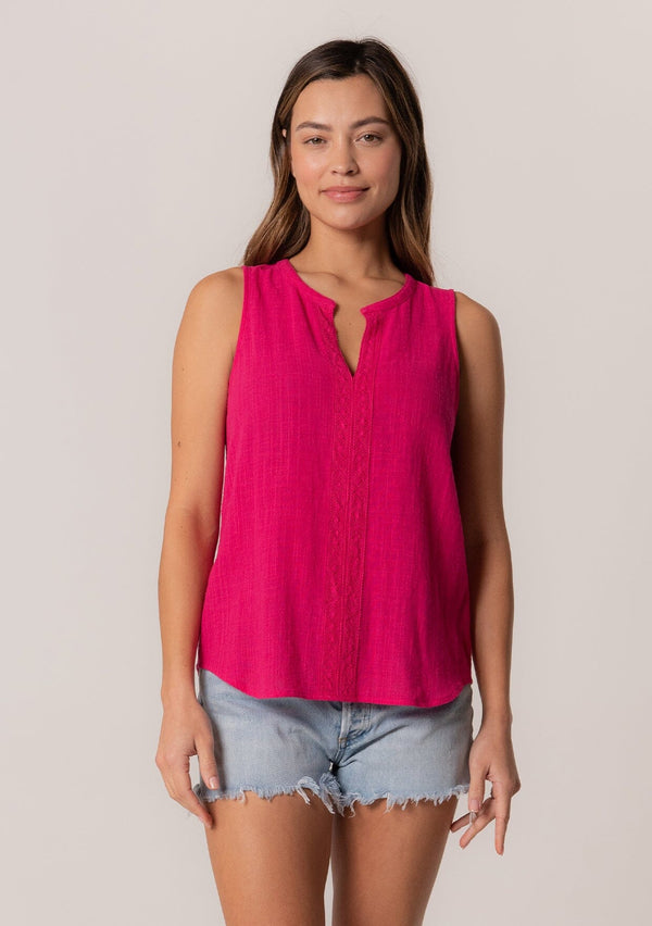 [Color: Fuchsia] A front facing image of a brunette model wearing a bohemian pink cotton tank top with a split v neckline, embroidered trim, and a relaxed fit.
