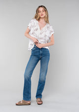 [Color: Natural/Taupe] A full body front facing image of a blonde model wearing a flowy bohemian spring top in a natural and taupe floral print. With short drop sleeves, a round neckline, and a self covered button front. 