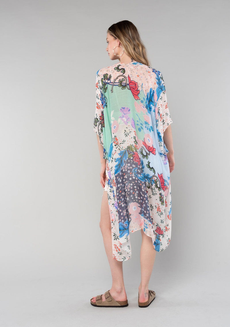 [Color: Natural/Coral] A back facing image of a blonde model wearing a lightweight bohemian kimono in a natural and coral mixed floral print. With half length kimono sleeves, an open front, and side slits. 