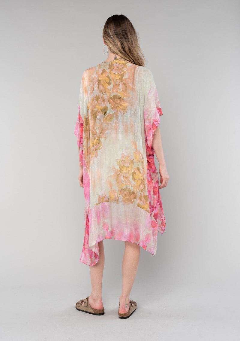 [Color: Mustard/Fuchsia] A back facing image of a blonde model wearing a lightweight bohemian mid length kimono in a mustard yellow and fuchsia pink watercolor floral print. With half length kimono sleeves, an open front, and side slits. 